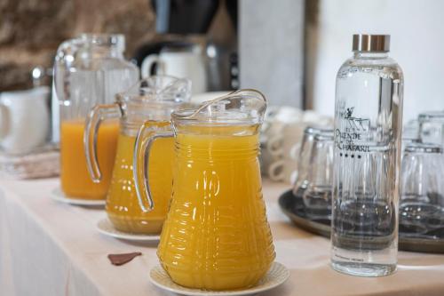 a bunch of glass pitchers of orange juice on a table at EL DUENDE DEL CHAFARIL in San Martín de Trevejo