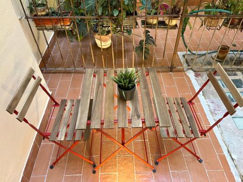 a wooden bench with a potted plant and two chairs at Domus Avi - Guest House in Rome