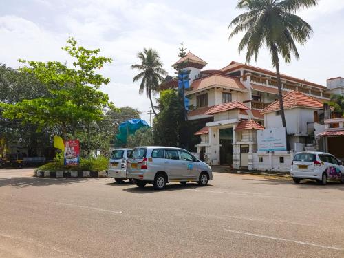 two cars parked in a parking lot next to a building at The Byke Puja Samudra in Kovalam
