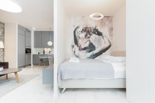 ワルシャワにあるMennica Residence - City Center Apartments by Noclegi Rentersの壁に絵が飾られたベッドのある寝室