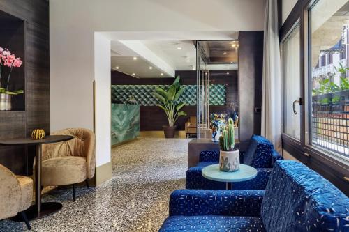 a lobby with blue couches and a table at Hotel American-Dinesen in Venice