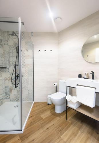 a bathroom with a toilet and a sink and a shower at Apartamentos Centro Llanes in Llanes