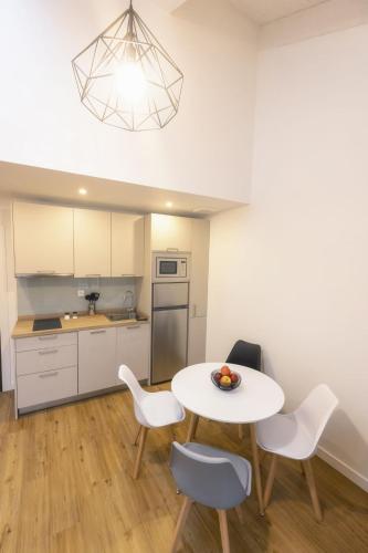 a kitchen with a table and chairs in a room at Apartamentos Centro Llanes in Llanes