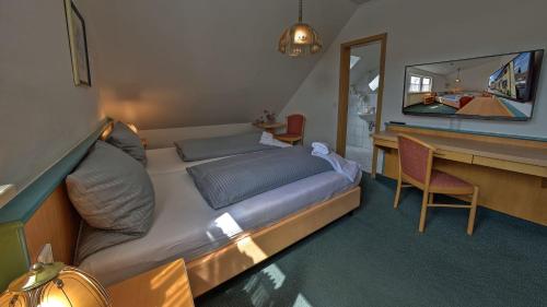 a bedroom with a bed and a desk with a mirror at Hotel Gasthof Lachner in Stetten