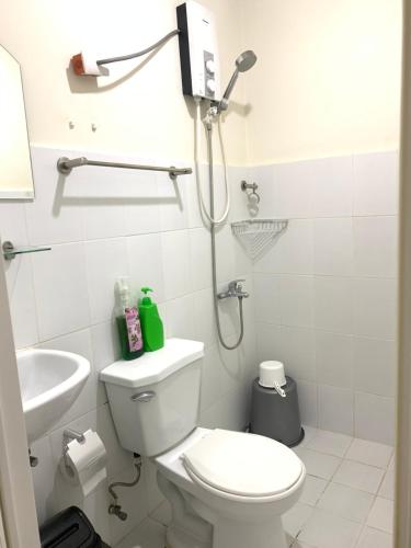 a white bathroom with a toilet and a shower at Luxanos Condo Place- San Marino in Cebu City