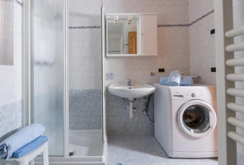 ein Badezimmer mit einer Waschmaschine und einem Waschbecken in der Unterkunft Stefano 1 in Livigno