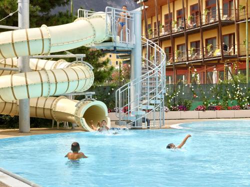 a group of people swimming in a swimming pool at a resort at Garda Sporting Club Hotel in Riva del Garda