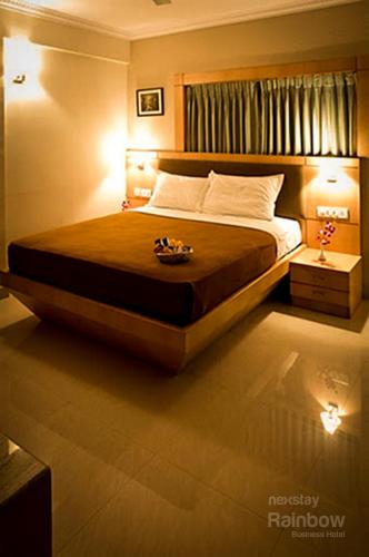 a bedroom with a large bed with lights on it at New Rainbow Business Hotel in Bengaluru