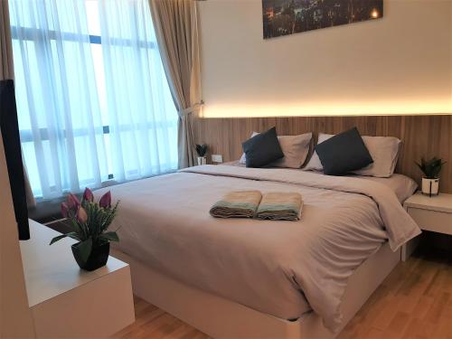 a bedroom with a large bed with two towels on it at Best Moments Suite in Kuantan