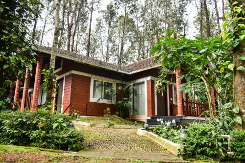 a red brick house in the woods at Coffee Grove Resort in Chikmagalūr