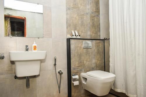 een badkamer met een toilet en een wastafel bij Nexstay Coffee Grove Resort in Chikmagalūr