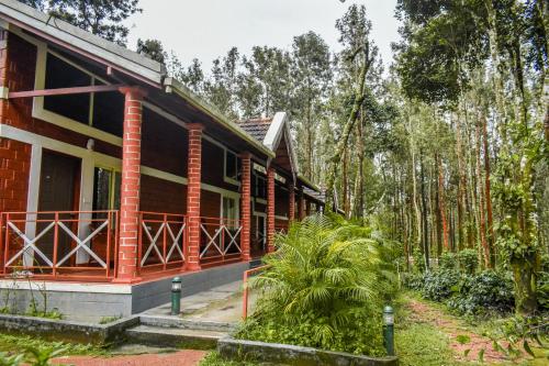 a house in the woods with trees in the background at Coffee Grove Resort in Chikmagalūr