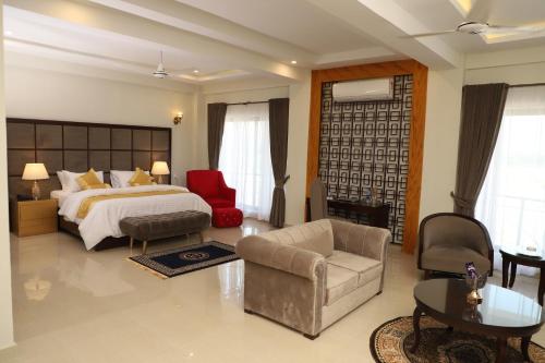 a bedroom with a bed and a couch and a chair at Swat Palace Hotel By Northin in Mām Derai