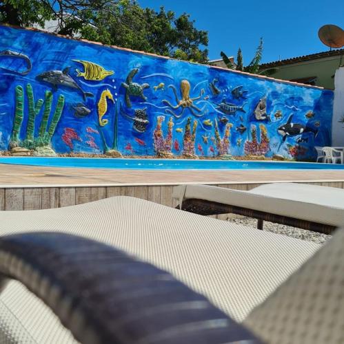 a mural of the ocean on a wall at Pousada Loft Praia dos Anjos in Arraial do Cabo