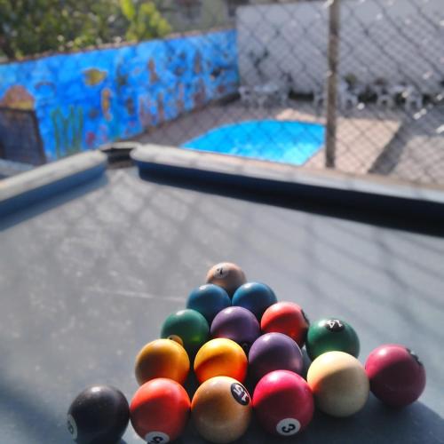 a pile of balls on top of a pool table at Pousada Loft Praia dos Anjos in Arraial do Cabo
