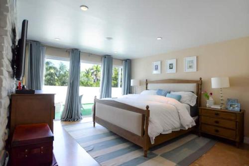 ein Schlafzimmer mit einem großen Bett und einem großen Fenster in der Unterkunft Villa Naomi - Luxury Design New Home in Miami