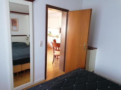 a bedroom with a door leading to a room with a bed at Sylter-Besserburg-App-3 in Westerland