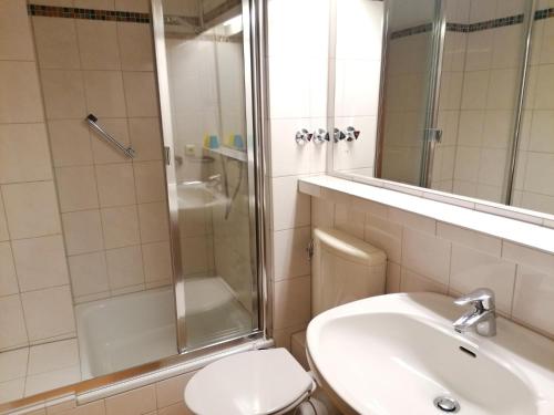 a bathroom with a toilet and a shower and a sink at Sylter-Besserburg-App-3 in Westerland
