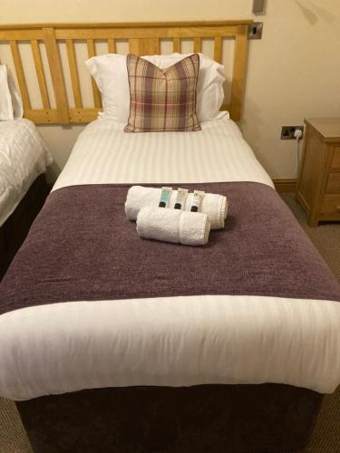 a bedroom with a bed with two towels on it at Pepper Street Rooms in Whitchurch