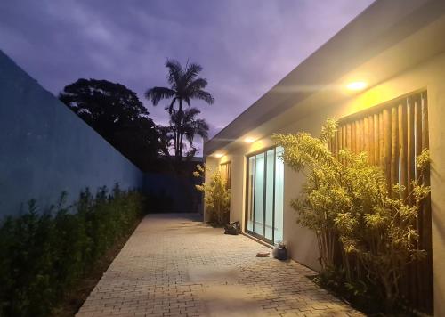 un chemin menant à une maison la nuit dans l'établissement Pousada Low Tide maresias, à Maresias