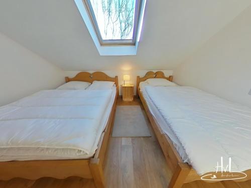 two twin beds in a room with a window at Chalet des Chauproyes in Ventron
