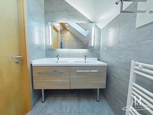 a bathroom with a sink and a mirror at Chalet des Chauproyes in Ventron