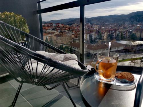 a glass of tea sitting on a table on a balcony at Sandev Apartments in Štip