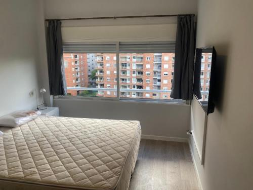 1 dormitorio con cama y ventana grande en espectacular departamento en Nuñez en Buenos Aires