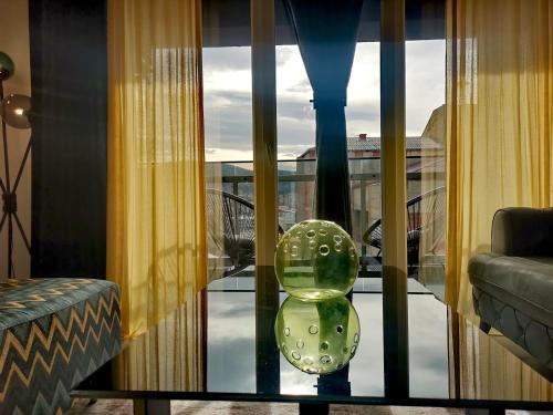 a vase sitting on a glass table in front of a window at Sandev Apartments in Štip