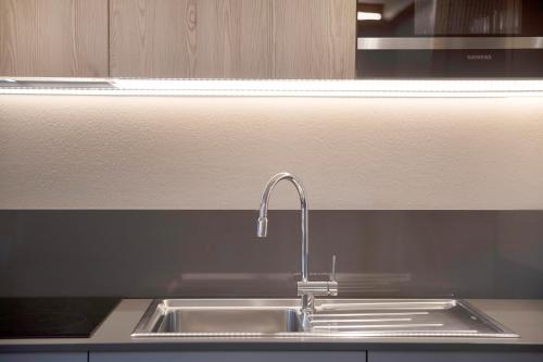a stainless steel kitchen sink with a faucet at Rasia Residence Relax Stone in Livigno
