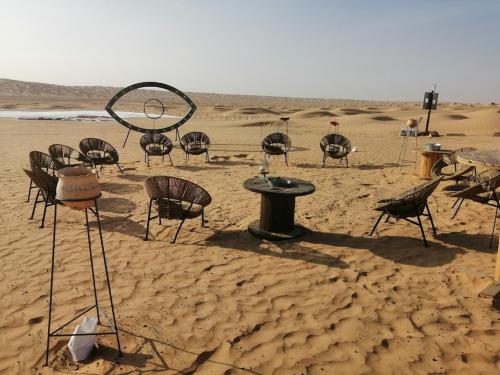 un groupe de chaises et de tables dans le désert dans l'établissement Camp Mars, à Douz