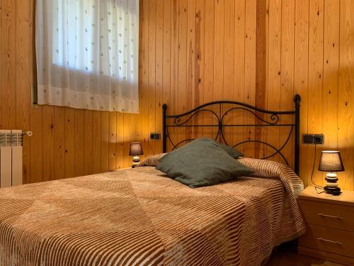 1 dormitorio con 1 cama con manta y 2 lámparas en Turisme Rural El Janpere, en Sant Joan de les Abadesses