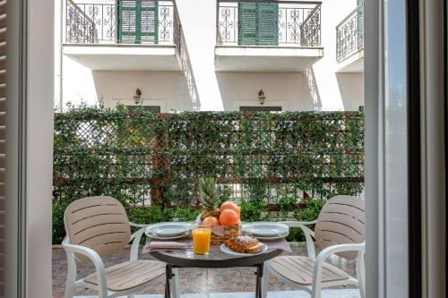 a table with a bowl of fruit and orange juice on a patio at KORINA APART HOTEL KAVOS in Kavos