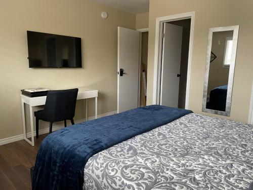Schlafzimmer mit einem Bett, einem Schreibtisch und einem TV in der Unterkunft Hammer Haus III in Waterloo