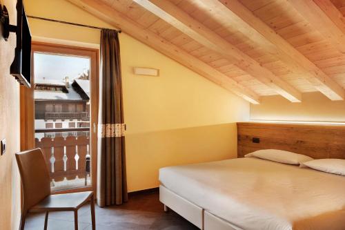 a bedroom with a bed and a window at Rasia Residence Relax Wood in Livigno