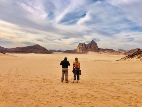 a man and a woman standing in the desert at Shakria Bedouin Life Camp in Wadi Rum