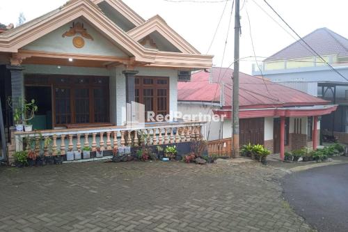 a house with a red harmonium sign on it at Gebby Homestay Bromo RedPartner in Pasuruan