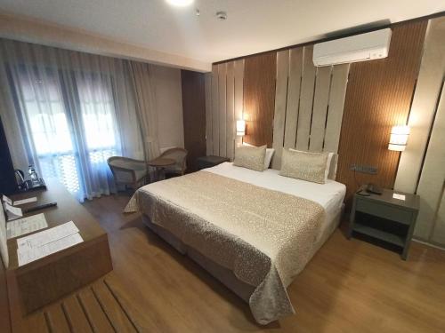 a hotel room with a large bed and a table at bahçelievler hotels in Ankara