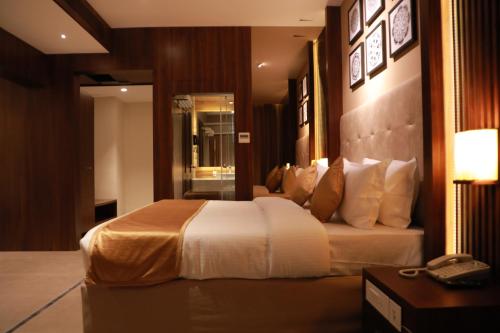 a bedroom with a large bed in a hotel room at Magnet Hotel in Kannur
