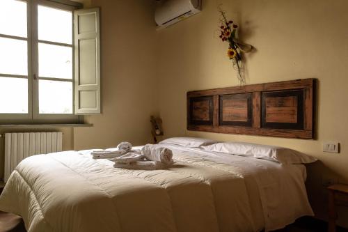 1 dormitorio con 1 cama blanca grande y toallas. en Agriturismo L'Olmo, en San Gimignano