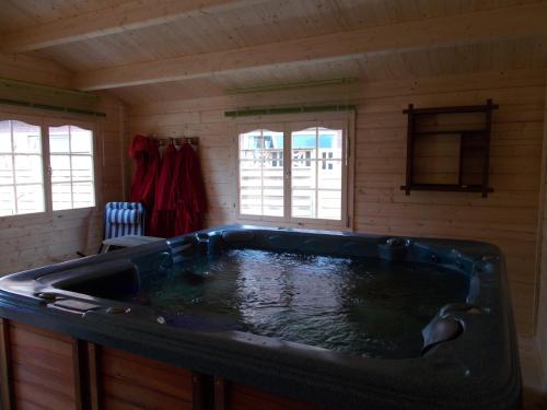 eine große Badewanne in einem Zimmer mit Fenstern in der Unterkunft Wieting´s Hotel in Esens