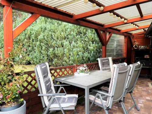 a patio with a table and chairs under a pergola at Ferienhaus Zschieck in Torno