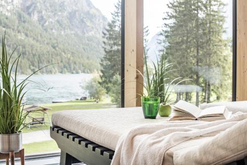 a bedroom with a bed with a book and a window at Hotel Fischer am See in Heiterwang