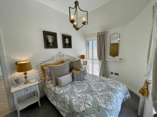 a bedroom with a bed and a table with a lamp at Salt Yard 1 - Stylish Whitstable Cottage - Free Parking - Beach - Harbour in Whitstable