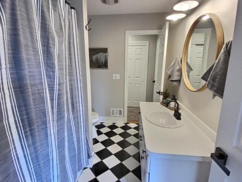 a bathroom with a sink and a mirror at The Ridge Chalet in Ellicottville Hot Tub & Sauna in Great Valley