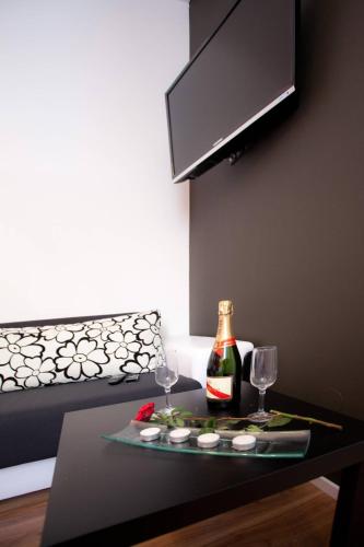a table with a bottle of wine and two glasses at Apartments Top Center in Zagreb