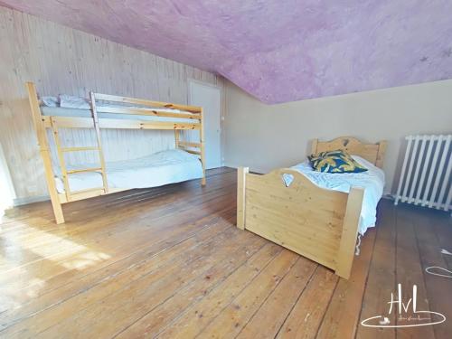 a bedroom with two bunk beds and a wooden floor at La demeure des tisserands in La Bresse