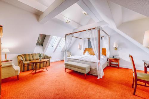 1 dormitorio con cama con dosel en el ático en Hotel Moosburger Hof en Pfaffenhofen an der Ilm