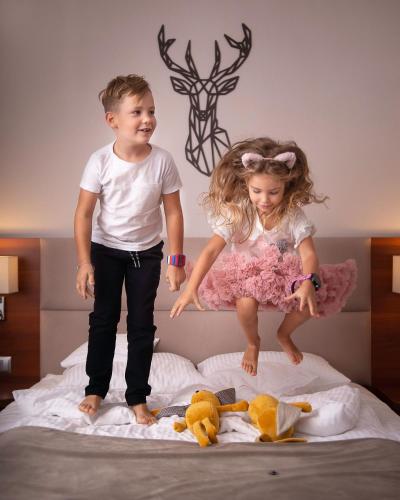 a boy and a girl jumping on a bed at ParkHotel Łysoń in Inwałd