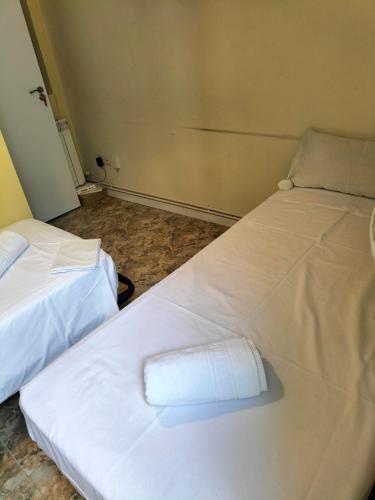 two beds in a room with white sheets at Santo Domingo Rooms in Madrid